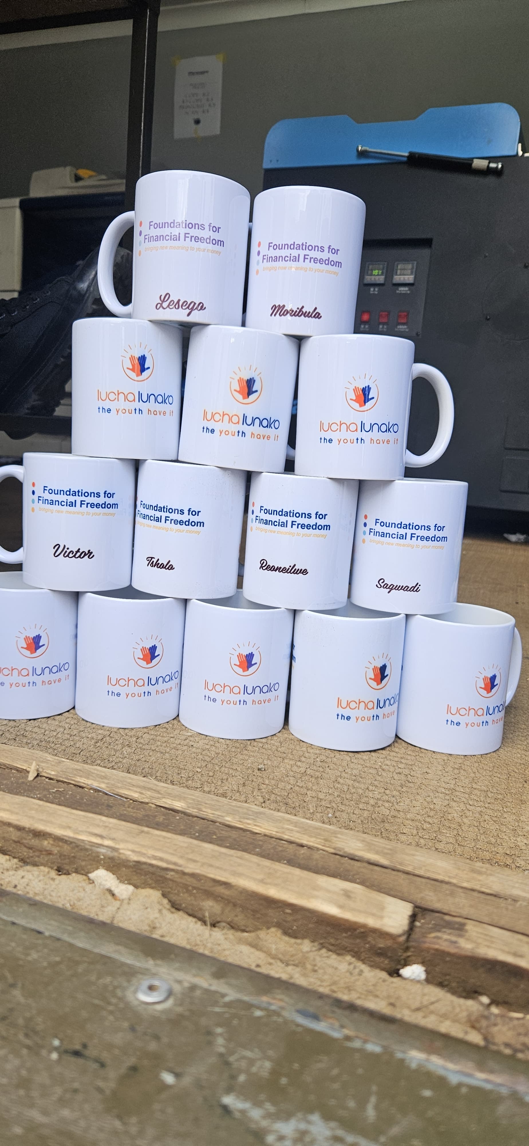 A stack of Lucha Lunako branded mugs with personalised names
